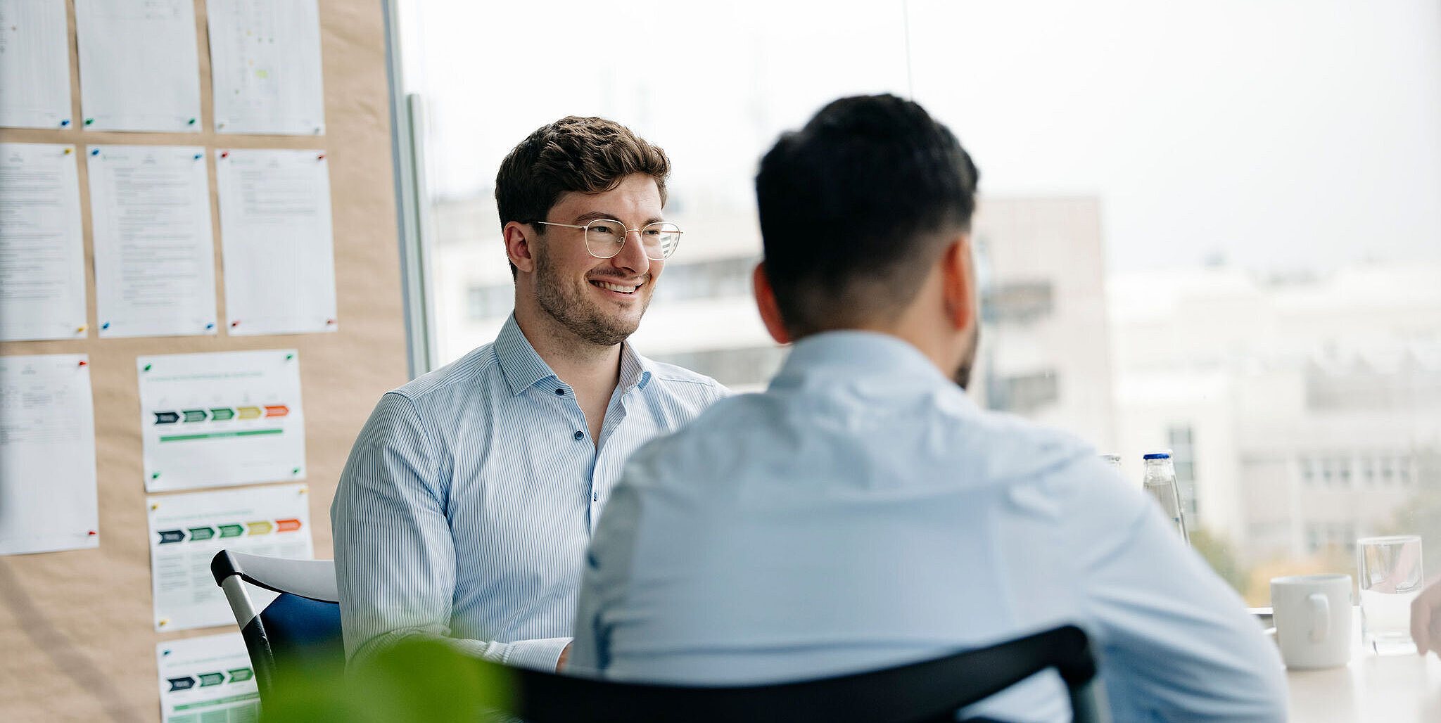 Mitarbeiter von Silver Atena im Gespräch während eines Meetings in einer modernen Arbeitsumgebung.