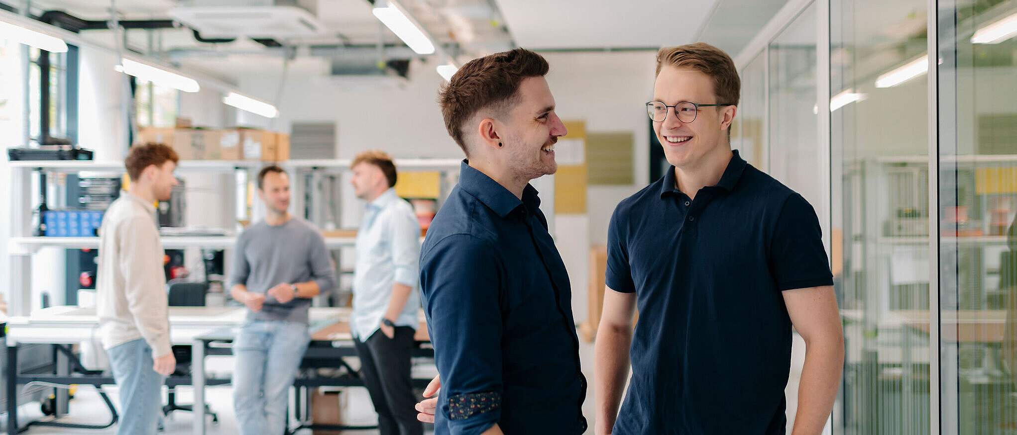 Mitarbeiter von Silver Atena im Gespräch in einer modernen Entwicklungs- und Arbeitsumgebung.