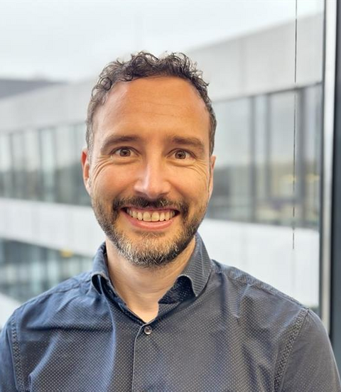 Mitarbeiterporträt im modernen Bürogebäude, professionelles Businessfoto.