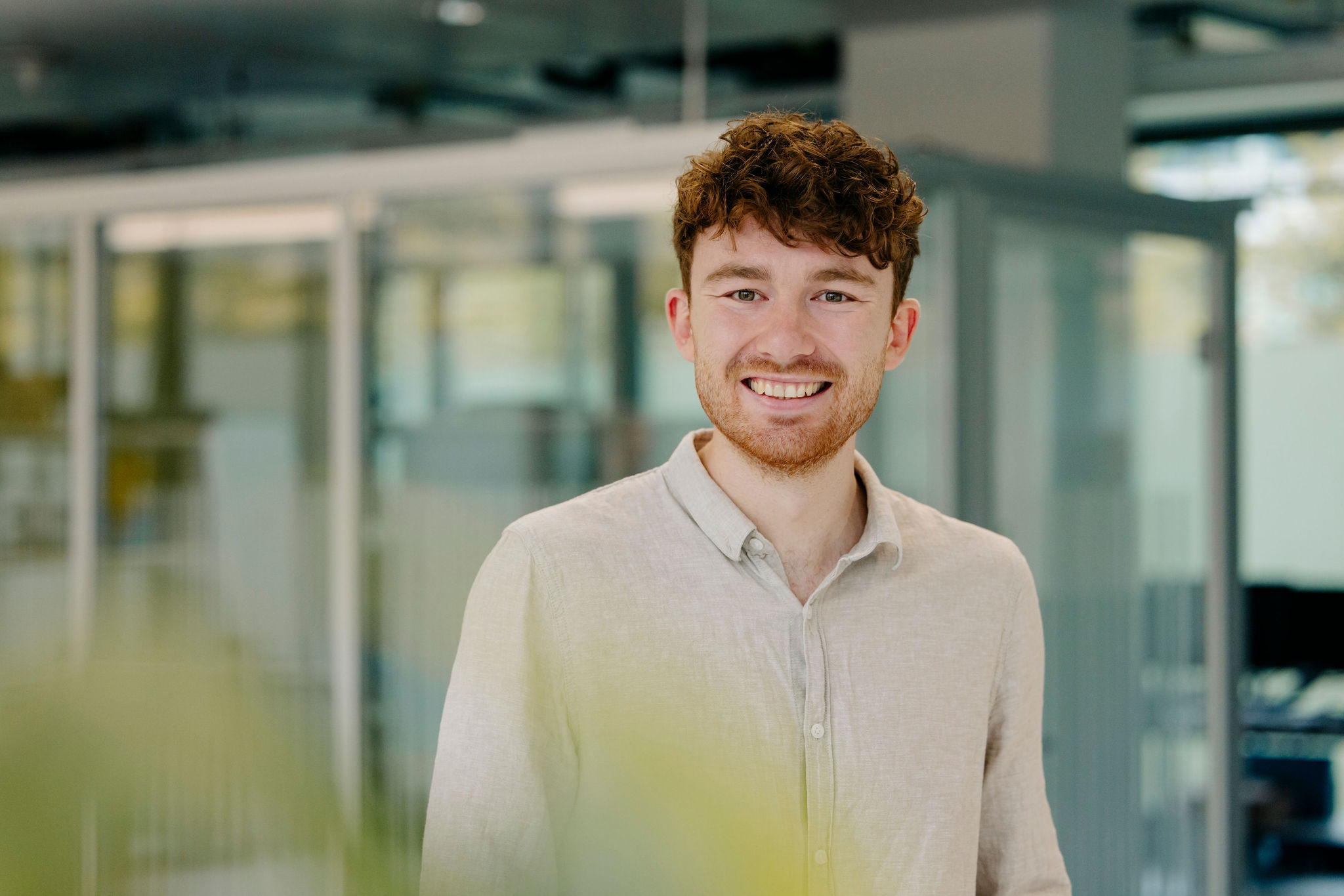 Lächelnder Mitarbeiter von Silver Atena in einer modernen Arbeitsumgebung.